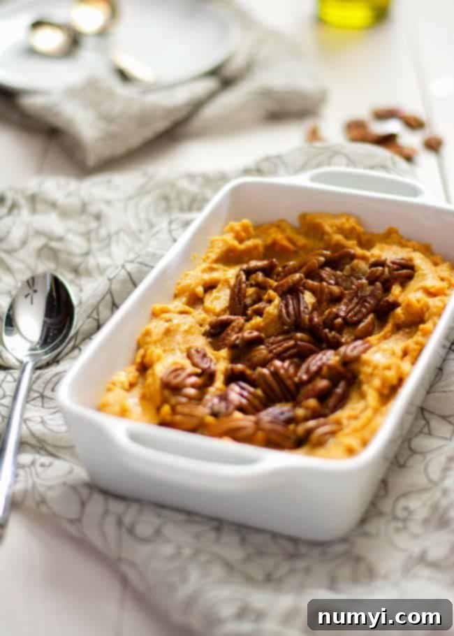 A Lighter Smoked Gouda and Sweet Potato Casserole with Spiced Pecans, offering a unique smoky and savory-sweet flavor profile, ideal for an elevated Thanksgiving side.