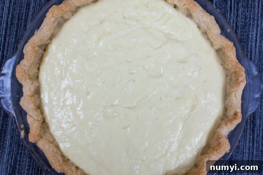 Coconut Cream Pie in baked crust, showing the smooth, creamy filling before topping.