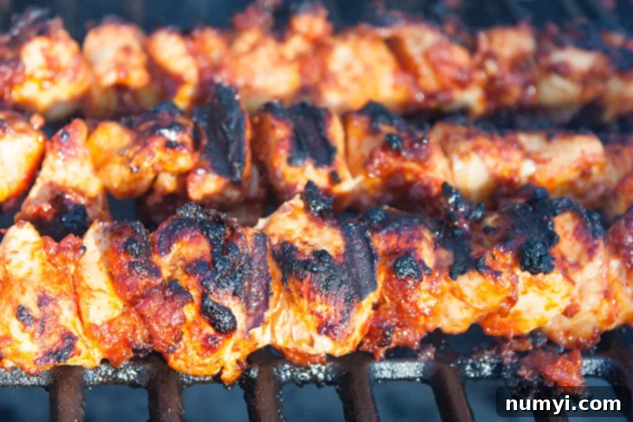 Grilled Bacon Paste BBQ Chicken Kebabs with a perfect char and glossy barbecue sauce glaze, still on the hot grill grates.