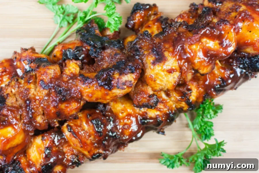 Fully cooked Bacon Paste BBQ Chicken Kebabs artfully arranged on a wooden cutting board, garnished and ready to be served.