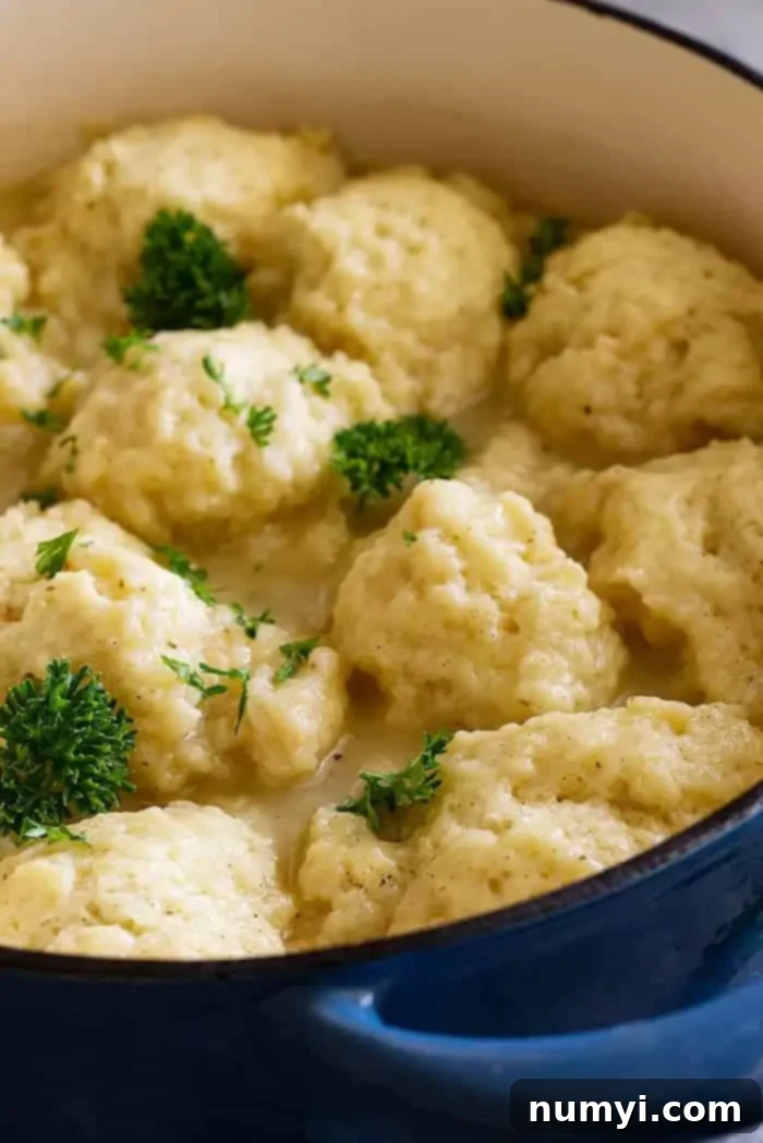 Creamy turkey dumpling soup in a pot garnished with parsley. 
