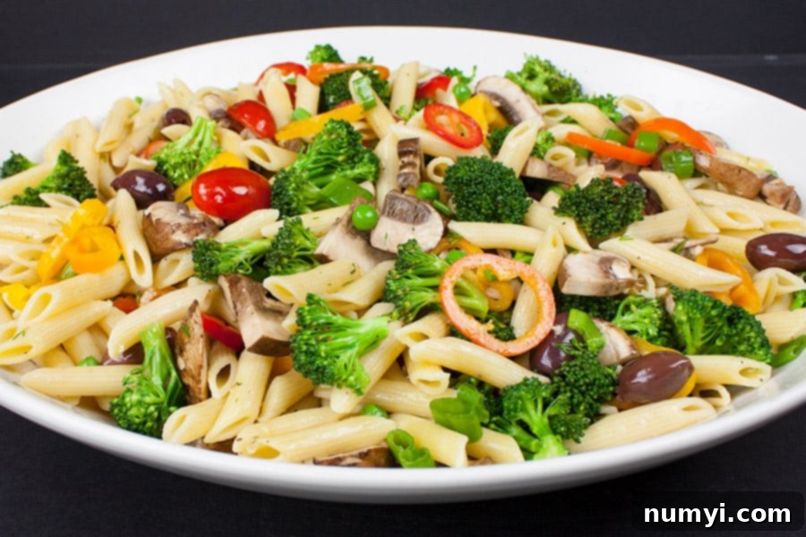 Lemony Garden Pasta Toss 2 Lemon Veggie Pasta Salad served in a shallow white bowl, showcasing vibrant vegetables and perfectly cooked pasta.
