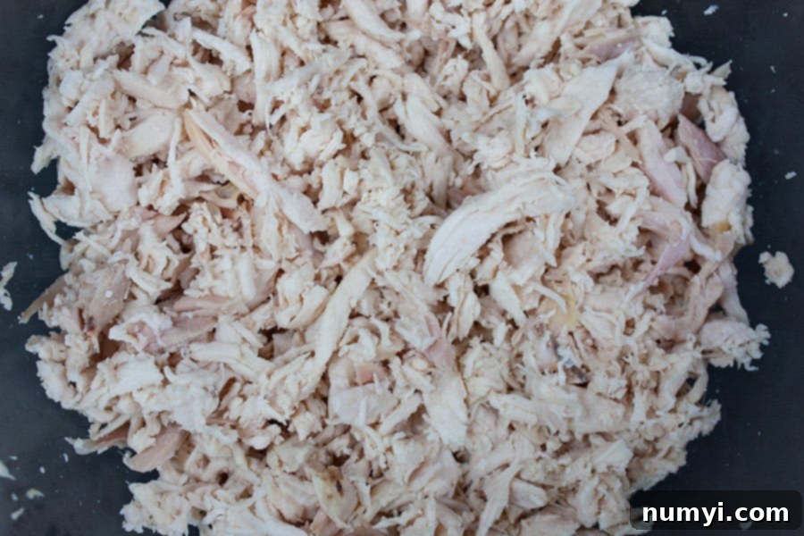 Quick and Delicious Chicken Salad 4 Savory Chicken Salad - shredded chicken in a glass mixing bowl