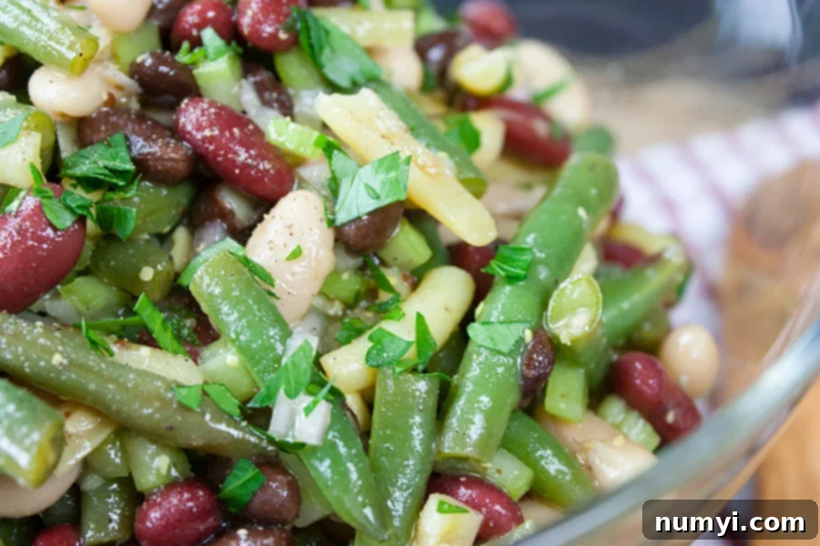 Homemade Five Bean Salad in a glass serving bowl, ready to be served.