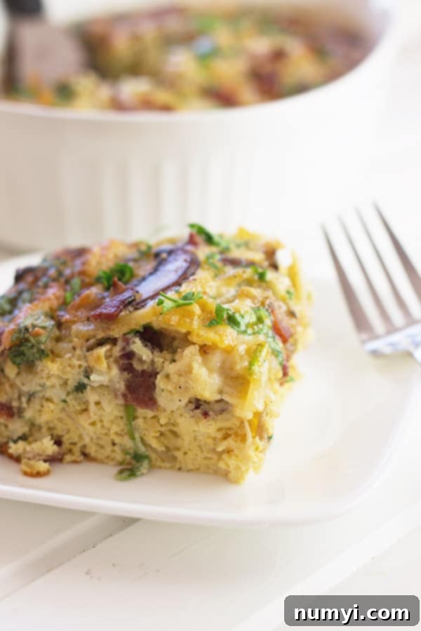 Savory Bacon Mushroom and Spinach Breakfast Casserole 2 A close-up photo of a generous slice of Bacon, Mushroom, and Spinach Breakfast Casserole, showcasing its layers of crispy bacon, tender mushrooms, vibrant spinach, and fluffy eggs baked to golden perfection.