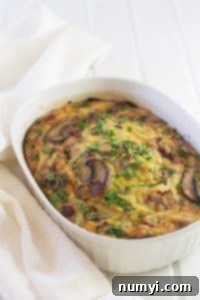 Savory Bacon Mushroom and Spinach Breakfast Casserole 4 Bacon, Mushroom, and Spinach Breakfast Casserole in a baking dish before serving, showing its appealing texture and golden crust.