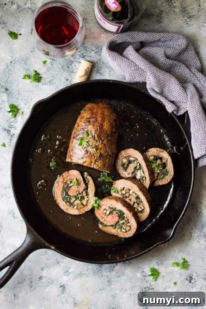 Cast iron skillet with partially sliced Mushroom and Blue Cheese stuffed flank steak. 