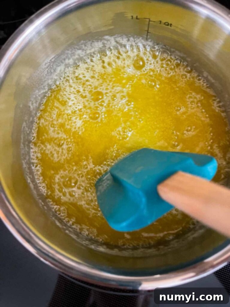 Butter browning in a saucepan over medium heat, showing the initial stages of melting and bubbling.