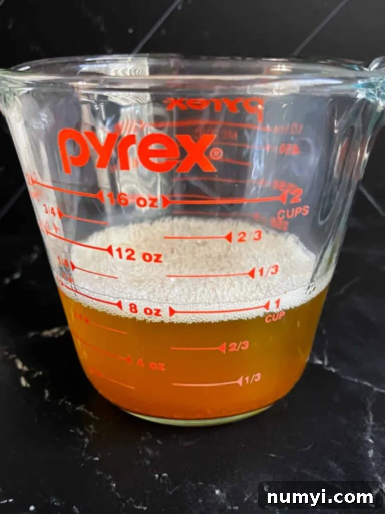 Melted brown butter in a glass measuring cup, cooled and ready for use in the cookie dough.