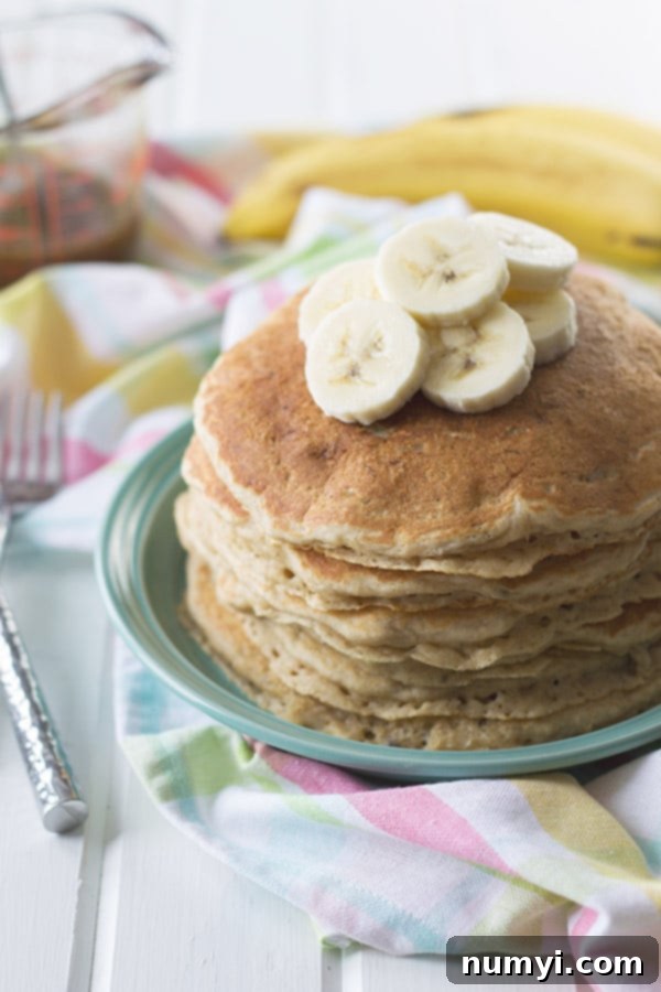 a stack of banana pancakes with sliced bananas on top