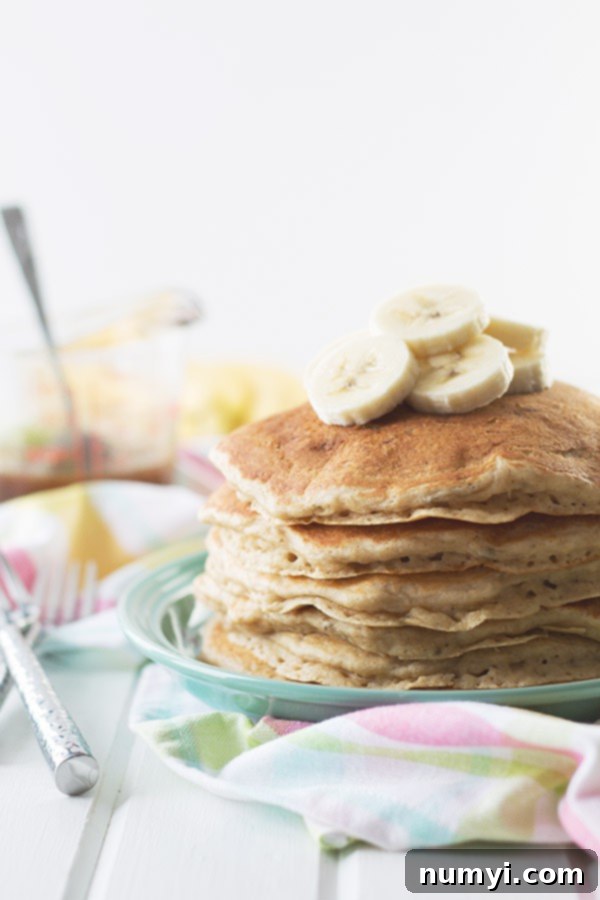 a stack of pancakes topped with slices of bananas on a blue plate