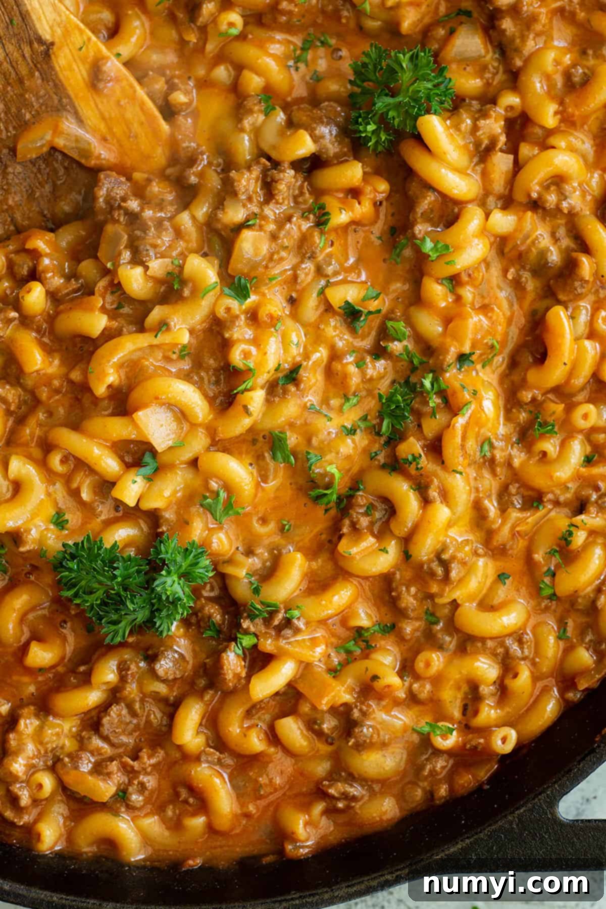 Close up of cheesy homemade hamburger helper garnished with fresh parsley.