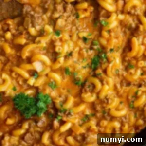 Close up of cheesy homemade hamburger helper garnished with fresh parsley.
