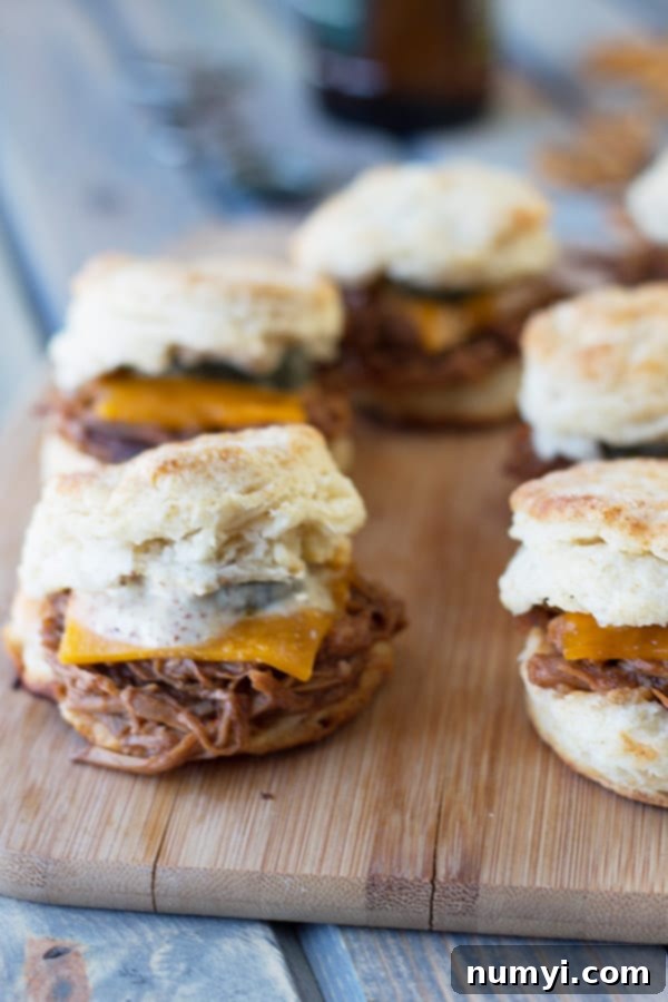 Close-up of a delicious BBQ Pulled Pork Biscuit Slider with melted cheddar and Dijon.