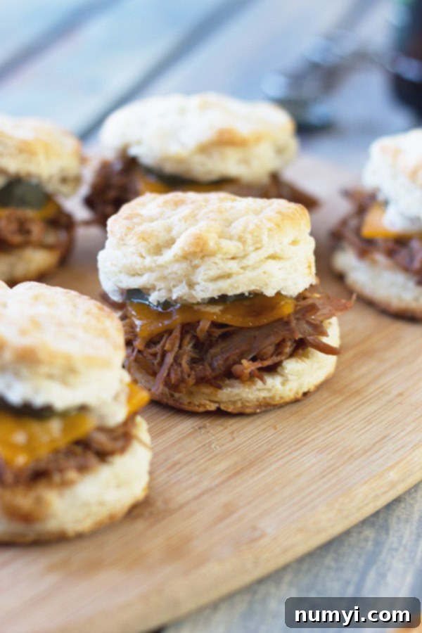 A plate of freshly baked BBQ Pulled Pork Biscuit Sliders with a golden crust.