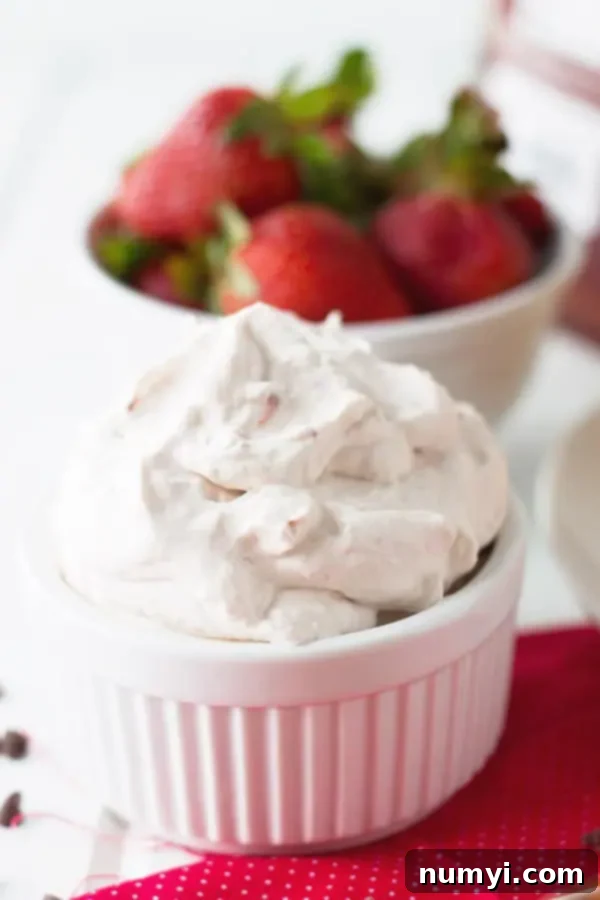 closeup: a ramekin full of homemade strawberry whipped cream for strawberry waffles, looking irresistibly smooth and creamy