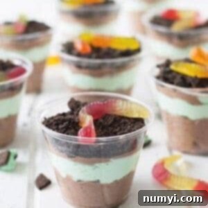 A visually appealing St. Patrick's Day Dirt Cup with vibrant green whipped cream and crushed Oreos.
