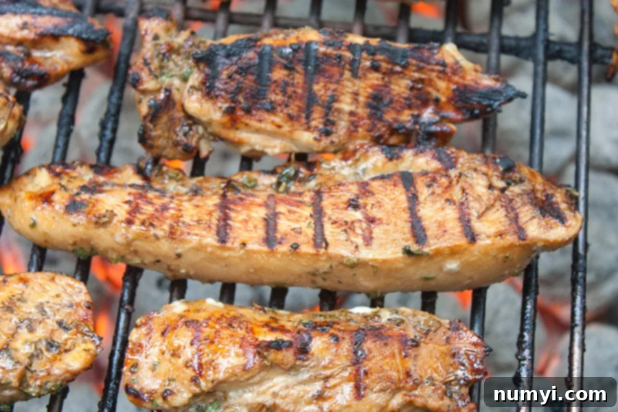 Marinated chicken pieces cooking on the grill.