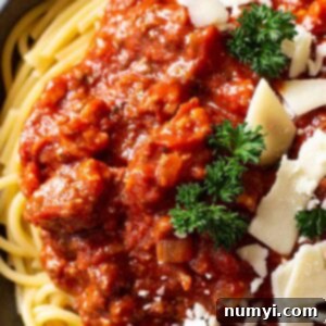 Easy Crock Pot Spaghetti Sauce 7 Close up of a spoonful of rich, homemade slow cooker spaghetti sauce over pasta with melted cheese.