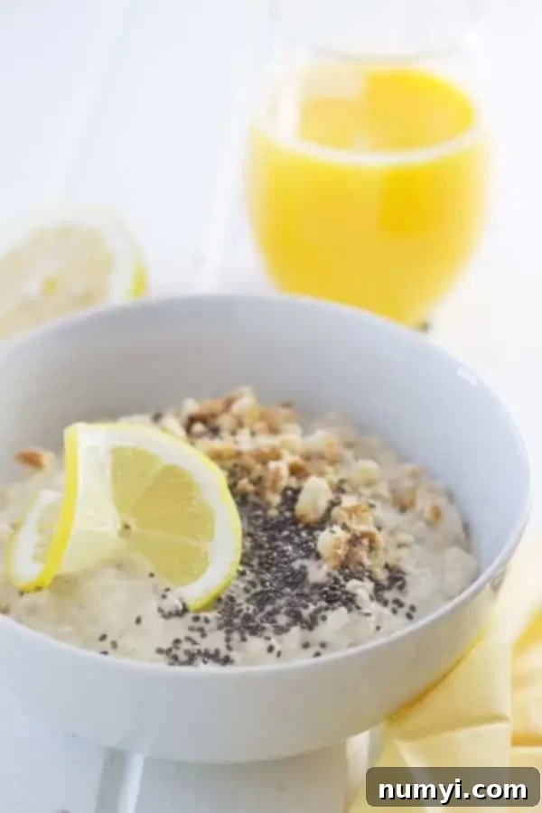Zesty Lemon Cheesecake Overnight Oats 3 A close-up shot of a bowl of Lemon Cheesecake Overnight Oats garnished with fresh lemon slices, crunchy Nilla wafers, and nutrient-rich chia seeds.