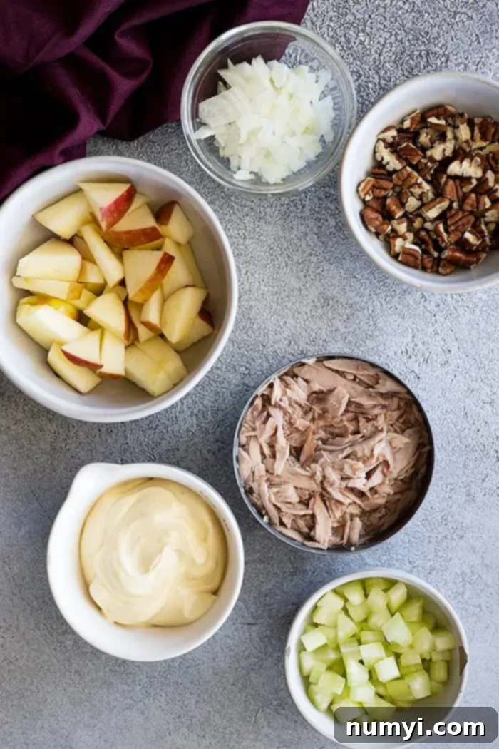 Crisp Apple Tuna Delight 3 Overhead view: A bowl of tuna with chopped apple and other ingredients laid out, ready for mixing.