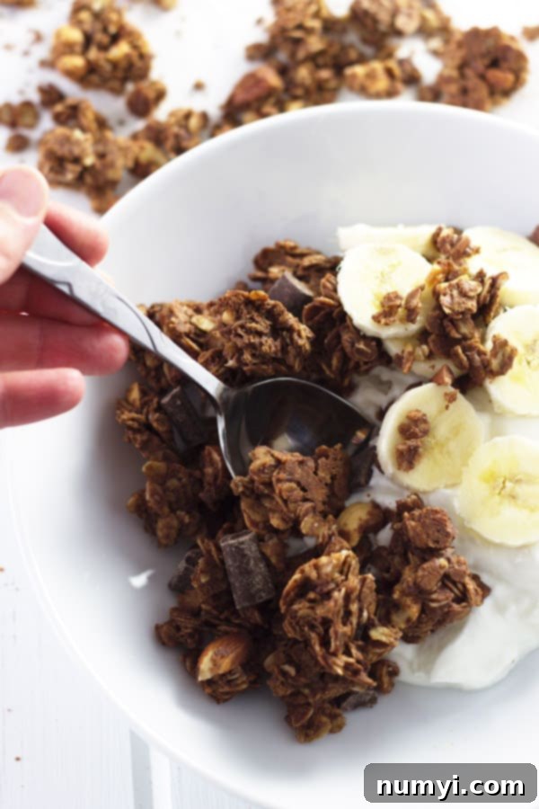 A baking pan filled with golden-brown chocolate peanut butter granola, cooling to form large clusters