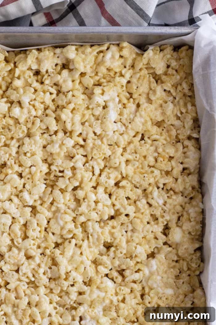 A pan of golden brown rice kirspie treats waiting to be cut into bars.