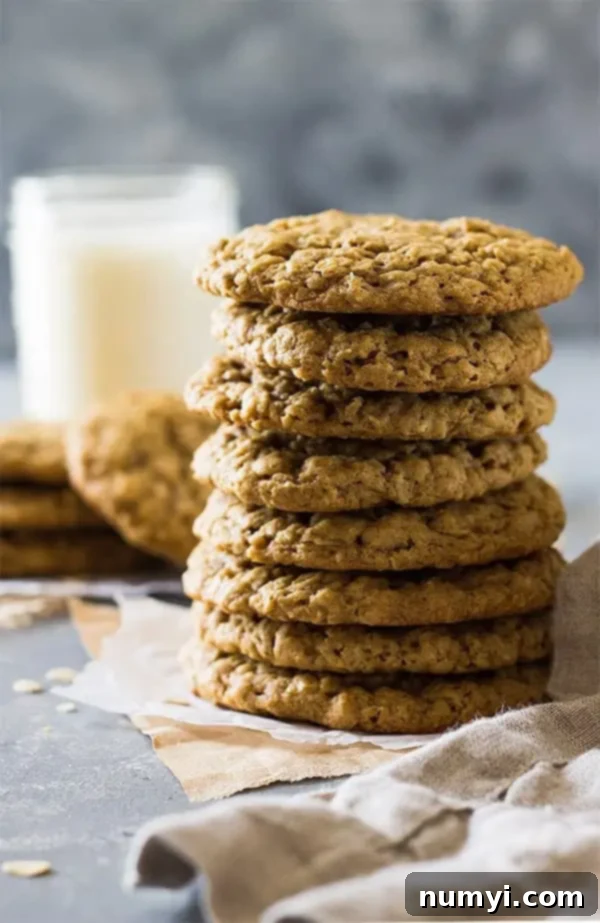 A tall stack of golden brown soft and chewy oatmeal cookies, ready to be enjoyed.