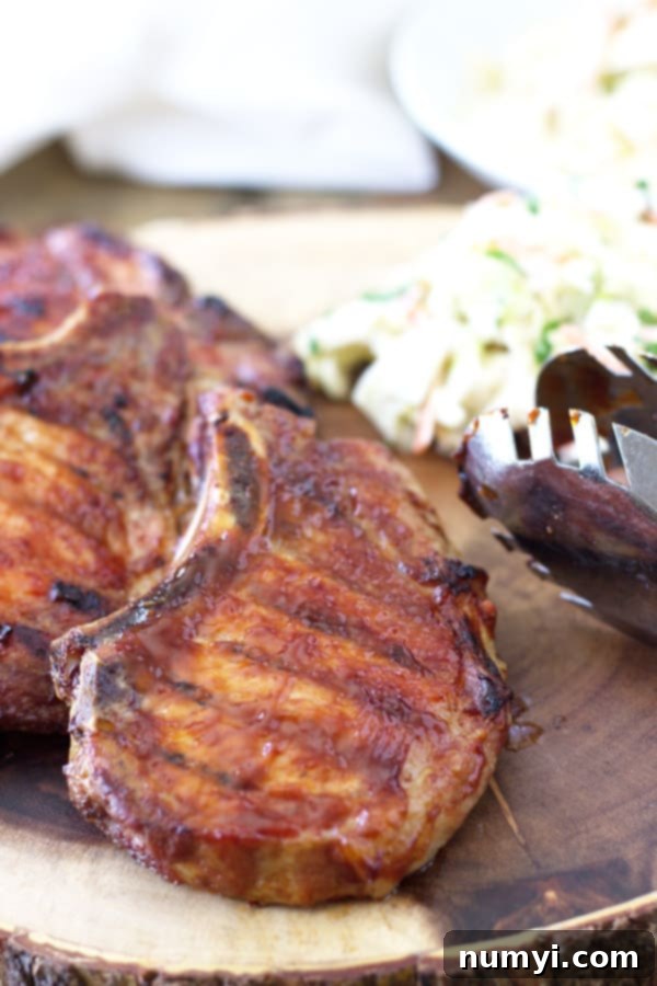 Effortless Smoked BBQ Pork Chops 2 Deliciously Quick Smoked BBQ Pork Chops ready to be served, showcasing a beautiful char and glaze.