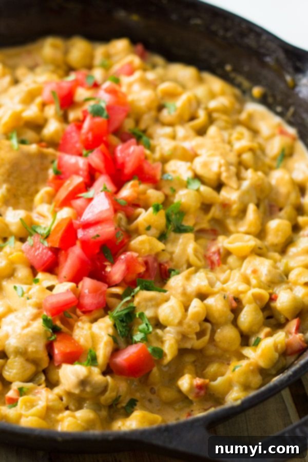 A large skillet of One Pot Southwestern Chicken Macaroni and Cheese, ready to be served