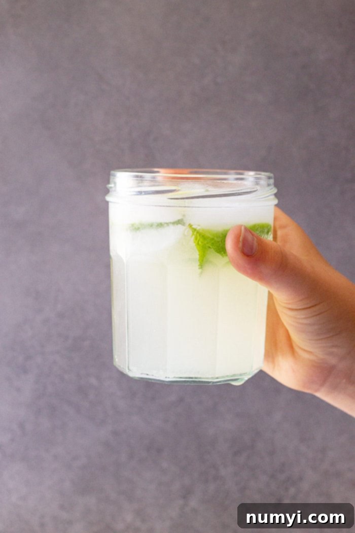 Refreshing Homemade Limeade 6 A glass of fresh limeade raised ready to drink.