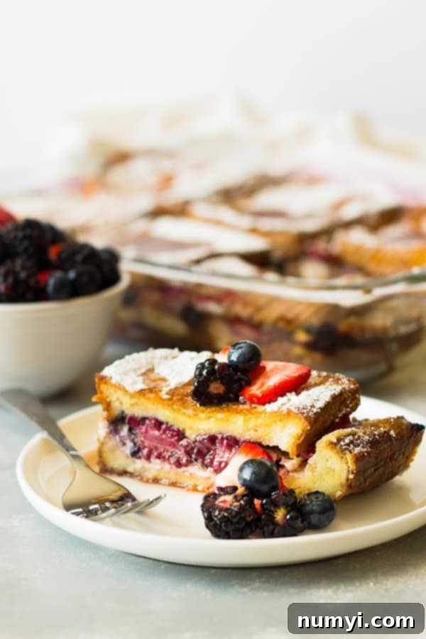 Spoonful of Triple Berry French Toast Casserole showing the creamy and fruity layers.
