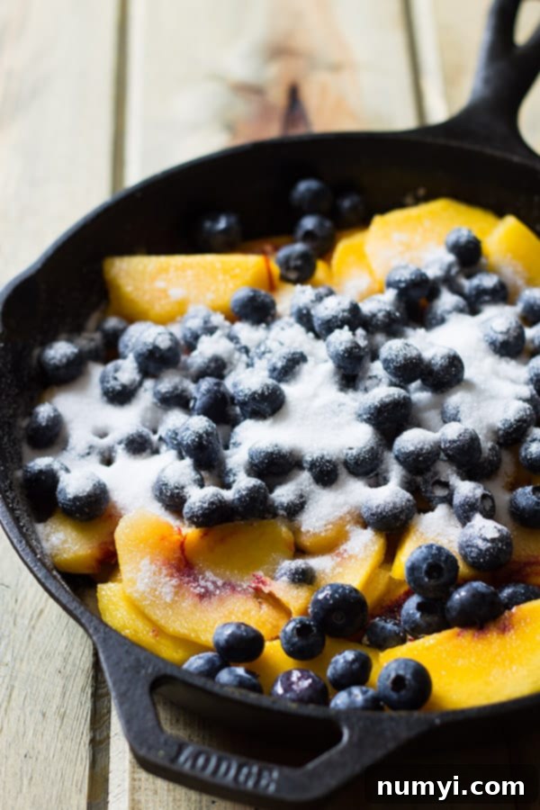 Delicious Blueberry Peach Cobbler, an easy homemade dessert made with fresh peaches and blueberries baked beneath a fluffy biscuit topping, served in a skillet.