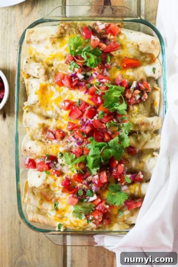 overhead: pan full of breakfast enchiladas recipe topped with fresh pico de gallo and cilantro