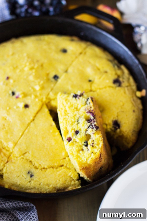 A close-up of the moist interior of Blueberry Peach Buttermilk Cornbread, showing delicious blueberries and peaches. | www.countrysidecravings.com