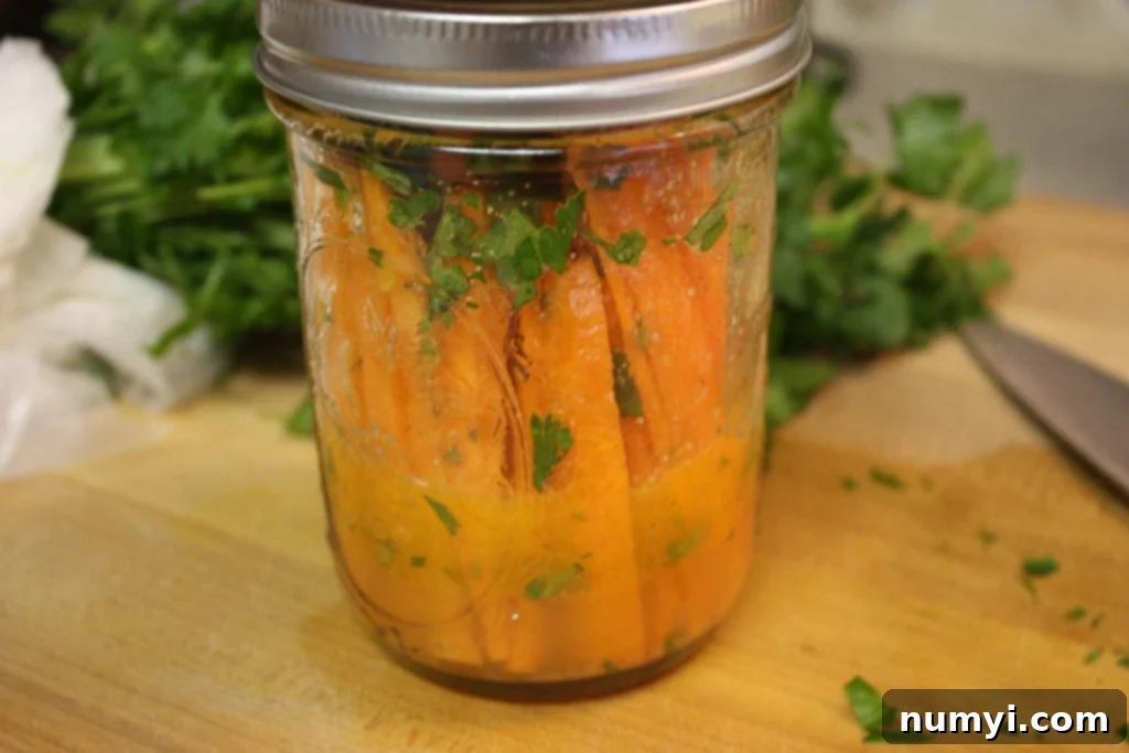 Zesty Marinated Carrot Sticks 2 Marinated carrot sticks in a mason jar.
