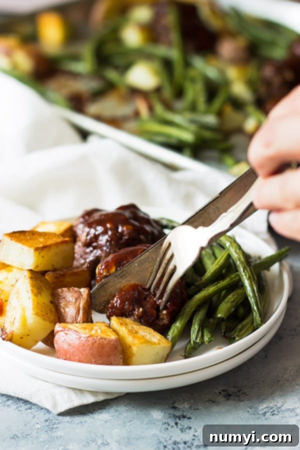 A vibrant plate featuring sheet pan BBQ meatballs, roasted green beans, and golden potatoes, highlighting the delicious balance and visual appeal of the meal.