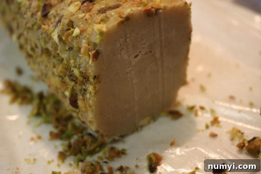 A chilled cookie dough log expertly sliced into uniform rounds, ready for baking.