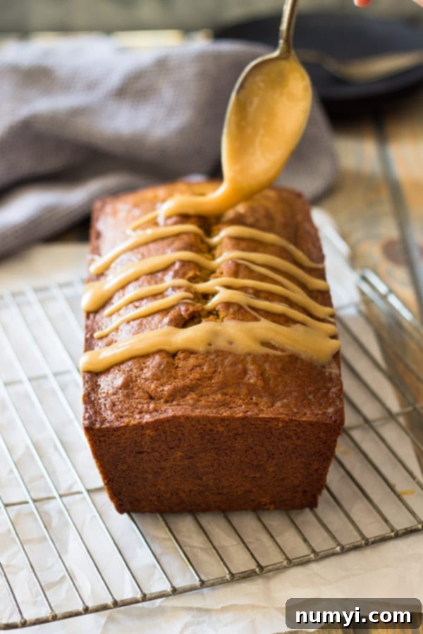 Slice of moist Pumpkin Bread with cream cheese caramel icing on a plate