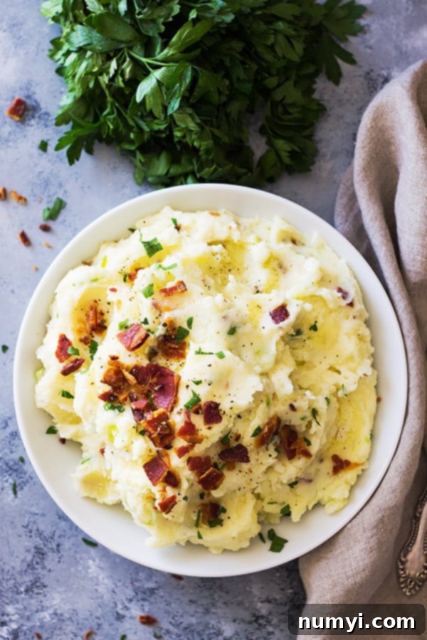 Bacon Mashed Potatoes are creamy, fluffy and full of flavor! Studded with crispy bacon, green onions and made ultra decadent with a little cream cheese. | www.countrysidecravings.com