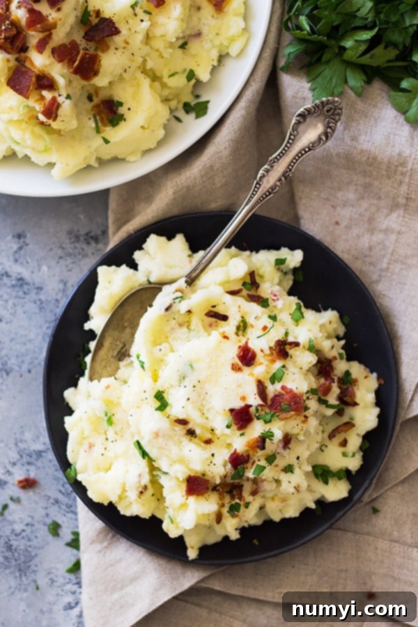 Bacon Mashed Potatoes are creamy, fluffy and full of flavor! Studded with crispy bacon, green onions and made ultra decadent with a little cream cheese. | www.countrysidecravings.com