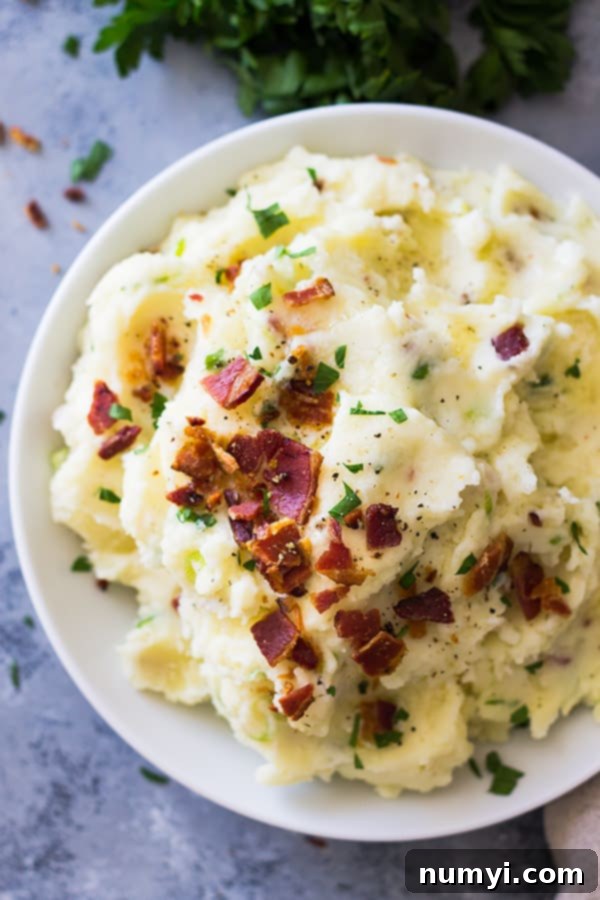 Bacon Mashed Potatoes are creamy, fluffy and full of flavor! Studded with crispy bacon, green onions and made ultra decadent with a little cream cheese. | www.countrysidecravings.com