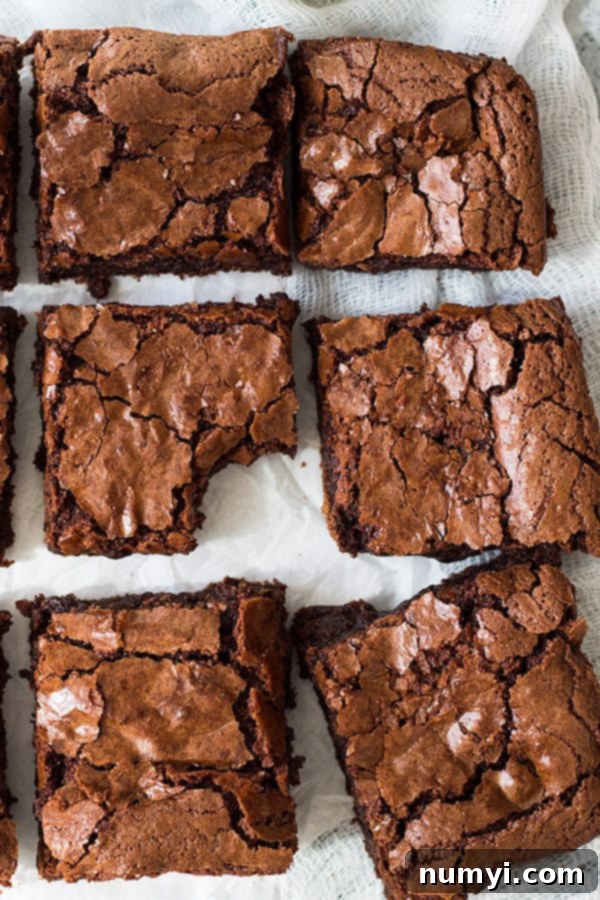 Perfect Homemade Chewy Brownies 3 Close-up view of a pan of freshly baked chewy brownies, cut into neat squares, highlighting the glossy, crackly top and rich, moist interior.