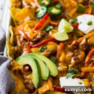 Sheet Pan Chicken Fajita Nachos with melted cheese and fresh toppings, ready to serve.