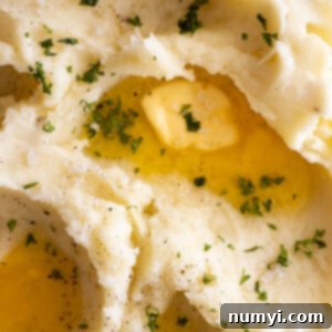 Effortlessly Delicious Garlic Mash 6 A high-angle shot of a bowl of creamy garlic mashed potatoes, perfectly garnished with fresh chives.