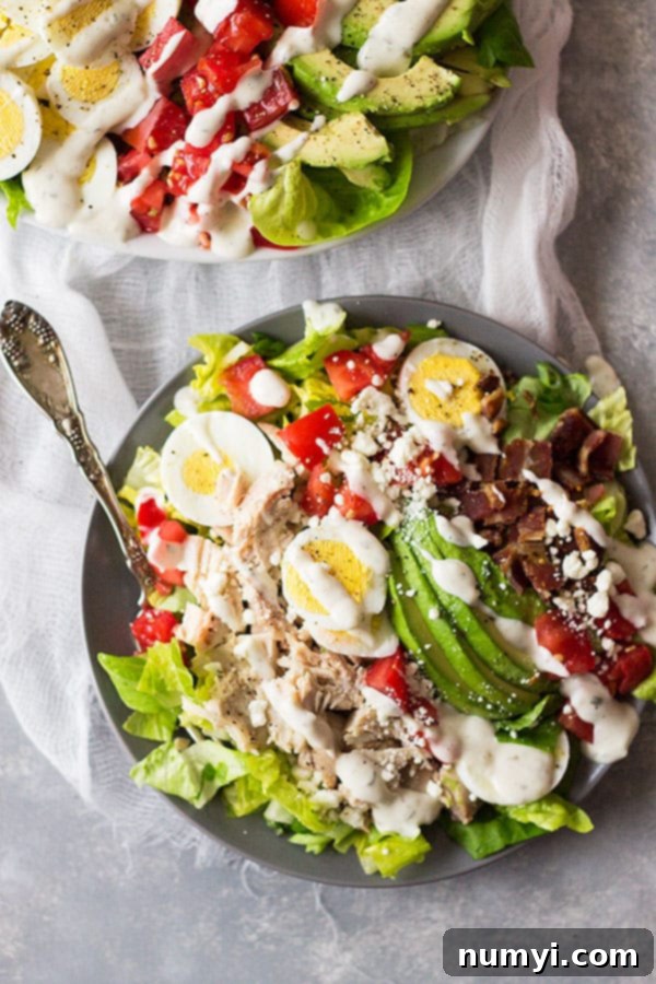 A vibrant Turkey Cobb Salad served on a rustic cutting board, showcasing the beautiful arrangement of fresh ingredients and making it an appealing healthy meal option.