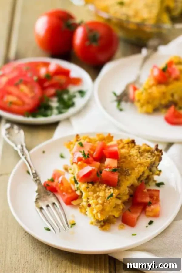 A perfectly portioned slice of the savory breakfast pie recipe on a white plate, ready to be enjoyed, with a fork beside it.
