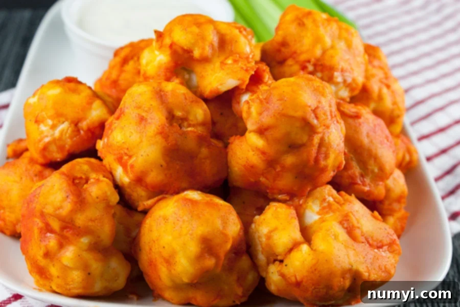 An inviting platter of finished Baked Buffalo Cauliflower Bites, artfully arranged and ready for serving, surrounded by fresh, crisp celery sticks and a bowl of creamy ranch dressing.