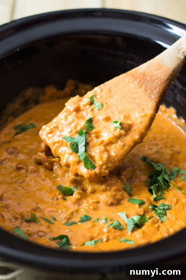 Rich and creamy homemade chili cheese dip made in a slow cooker, served with tortilla chips