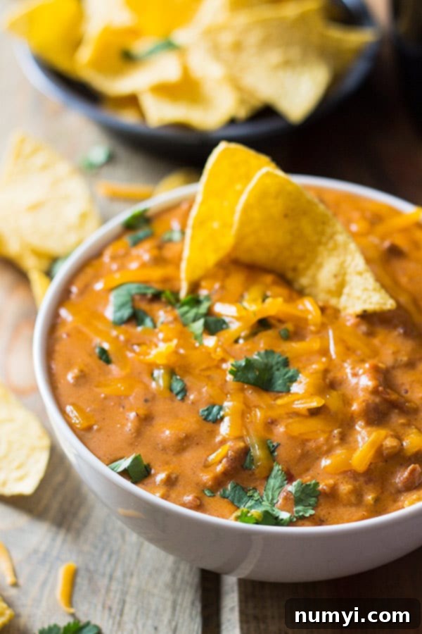 Close-up of bubbling homemade chili cheese dip in a slow cooker, ready to serve